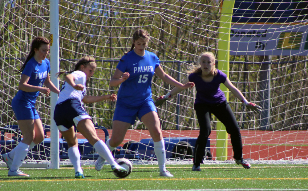 Rachel Ellert kicks the ball into the goal, despite Palmer defense and goalie efforts. The Mariner girls beat Palmer 7-1 on Saturday, May 7.-Photo by Anna Frost; Homer News