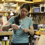 Iris Neary wraps tape around an ice axe she will take with her to Denali. The group modified a lot of their gear, making it lighter or better functioning to their needs.-Photo by Anna Frost, Homer News