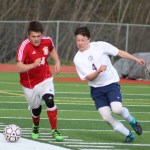 Homer sophomore Timothy Blakely charges at the ball in an attempt to keep it away from a his opponent during the April 26 home game against Kenai. Homer lost to Kenai, 5-1.-Photo by Anna Frost; Homer News