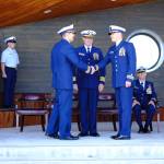 At a change of command ceremony on July 18, 2018 command of the USCGC Hickory is handed from Commander Andrew Passic (left) to Lt. Commander Adam Legget (second to right) at the Homer Boat House in Homer, Alaska. Overseeing the change of command is Capt. Patrick Hilbert (second to left) and Chaplain Lt. Gary Pepper (right). The ceremony took place in the new Homer Boat House at the Homer Harbor. (Photo by PO2 Andrew Keenan, Marine Safety Detachment Homer, United States Coast Guard)