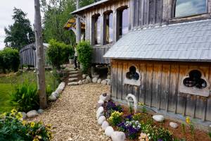 Drifwood and rock is used to line the gardens at the Jeff and Ranja Dean farm off East End Road in Homer, Alaska. It was one of five gardens featured in the July 29, 2018 Homer Garden Tour. (Photo by Michael Armstrong/Homer News)