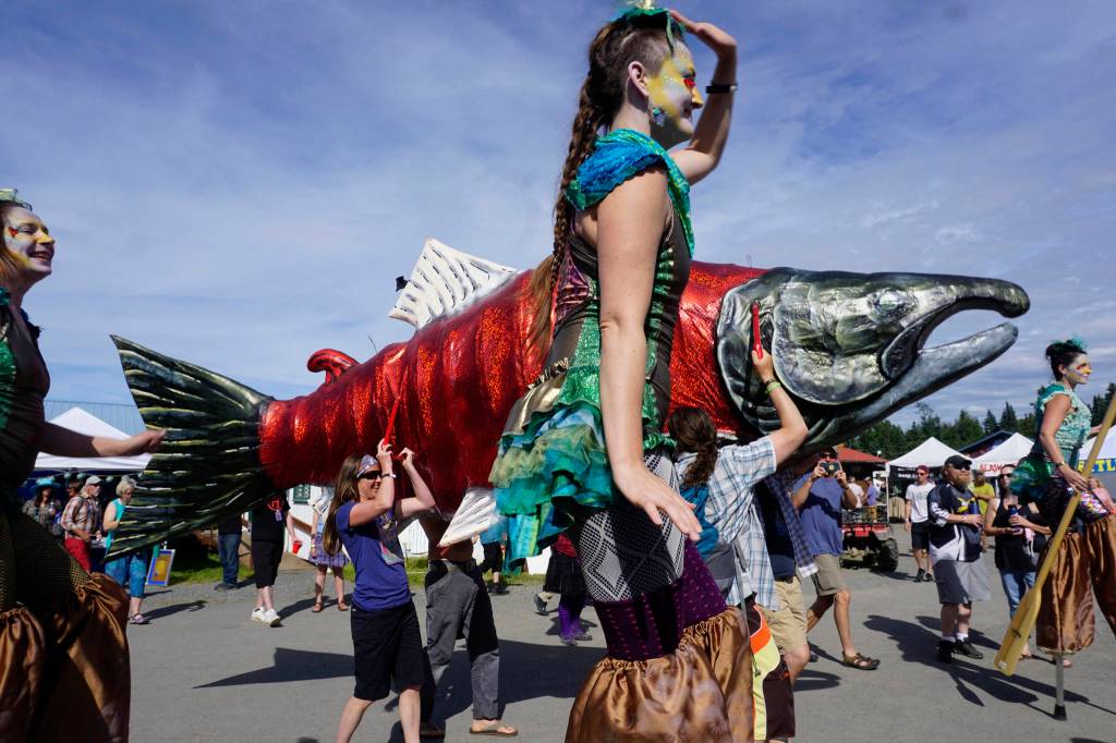 An art and music performance during Salmonfest on Saturday, Aug. 4, 2018, featured women on stilts dressed as mermaids, salmon sculptures and the LowDown Brass Band. Salmonfest attendees enjoyed warm sunny weather on Saturday at the Kenai Peninsula Fairgrounds in Ninilchik, Alaska. (Photo by Michael Armstrong/Homer News)