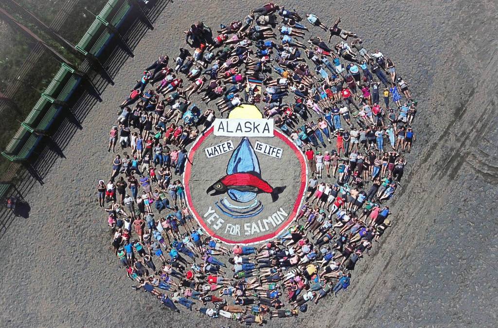 Festival goers and volunteers lie on the ground to form the annual art project at Salmonest on Saturday, Aug. 4, 2018 at the Kenai Peninsula Fairgrounds in Ninilchik, Alaska. The theme of this years presentation, coordinated by Homer artist Mavis Muller, is Water is Life and Yes for Salmon, the latter a reference to a ballot proposition to change Alaska law when it comes to streams and other waters. (Photo courtesy Cook Inletkeeper)