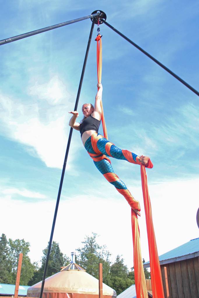 An aerial performer spins in the air next to the Ocean State at this years Salmonfest on Saturday, Aug. 4, 2018 at the Kenai Peninsula Fairgrounds in Ninilchik, Alaska. (Photo by Megan Pacer/Homer News)