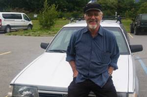 Bumppo Bremicker leans on his 1992 Subaru Loyale on Aug. 10, 2018 in the Homer Public Library parking lot in Homer, Alaska. (Photo by Mira Klein)