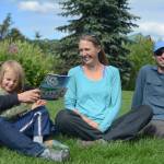 Janet Klein, left, holds her grandson, Sylas Reising, 4, while she visits with her daughter, Deborah Klein, center, and son-in-law George Reising, right, at Bishops Beach, Homer, Alaska, on Aug. 9, 2018. Not shown is Kai Reising, 6. Silas and Kai were the inspiration for the Kleins color and learn book, Alaskas Dinosaurs and Other Cretaceous Creatures.