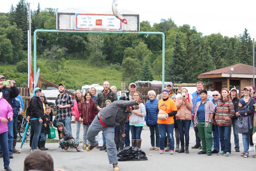 A man launches a salmon into the air during the fish toss, and even held during the annual Kenai Peninsula Fair, on Saturday, Aug. 18, 2018 at the fairgrounds in Ninilchik, Alaska. (Photo by Megan Pacer/Homer News)