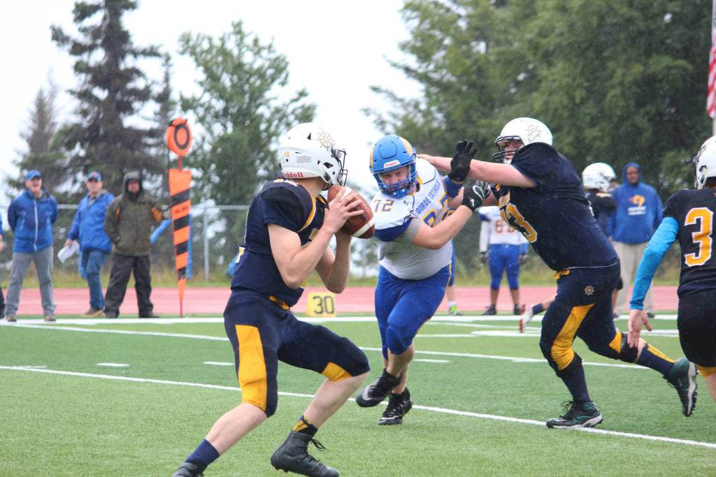 Monroe Catholic High Schools Alex VanWhye heads for Homers quarterback, Anthony Kalugin, while he searches for an opening during their game Saturday, Aug. 25, 2018 at the turf field in Homer, Alaska. The Rams eked out a win over Homer, defeating them 28-27. (Photo by Megan Pacer/Homer News)