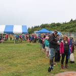 Area residents wait in a line that snakes around Karen Hornaday Park for some grilled salmon during a barbecue for Wild Alaska Salmon Day, held Friday, Aug. 10, 2018 at the park in Homer, Alaska. (File Photo by Megan Pacer/Homer News)