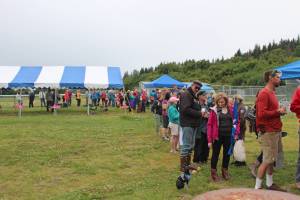 Area residents wait in a line that snakes around Karen Hornaday Park for some grilled salmon during a barbecue for Wild Alaska Salmon Day, held Friday, Aug. 10, 2018 at the park in Homer, Alaska. (File Photo by Megan Pacer/Homer News)