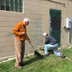 Homer-Kachemak Bay Rotarians Charlie Welles, left, rakes up paint chips while Maynard Gross, right, puts a new coat of paint on the restrooms at Ben Walters Park on June 9, 2018, in Homer, Alaska. (Photo provided)