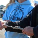 Richard Bumppo Bremicker, president of the Kachemak Bay Wooden Boat Society, shows Carol Sacheck how to tie a bowline knot Saturday, Sept. 1, 2018 during the Kachemak Bay Wooden Boat Festival on the Homer Spit in Homer, Alaska. (Photo by Megan Pacer/Homer News)