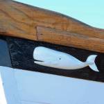 A carved whale decorates the bow of a boat on display Saturday, Sept. 1, 2018 at the Kachemak Bay Wooden Boat Festival on the Homer Spit in Homer, Alaska. (Photo by Megan Pacer/Homer News)
