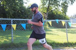 Sean Campbell reaches the finish line of the Homer Mariner Triathlon on Saturday, Sept. 1, 2018 at Homer High School in Homer, Alaska. He completed the running leg of the race for his team, Gutzlers Return. (Photo by Megan Pacer/Homer News)