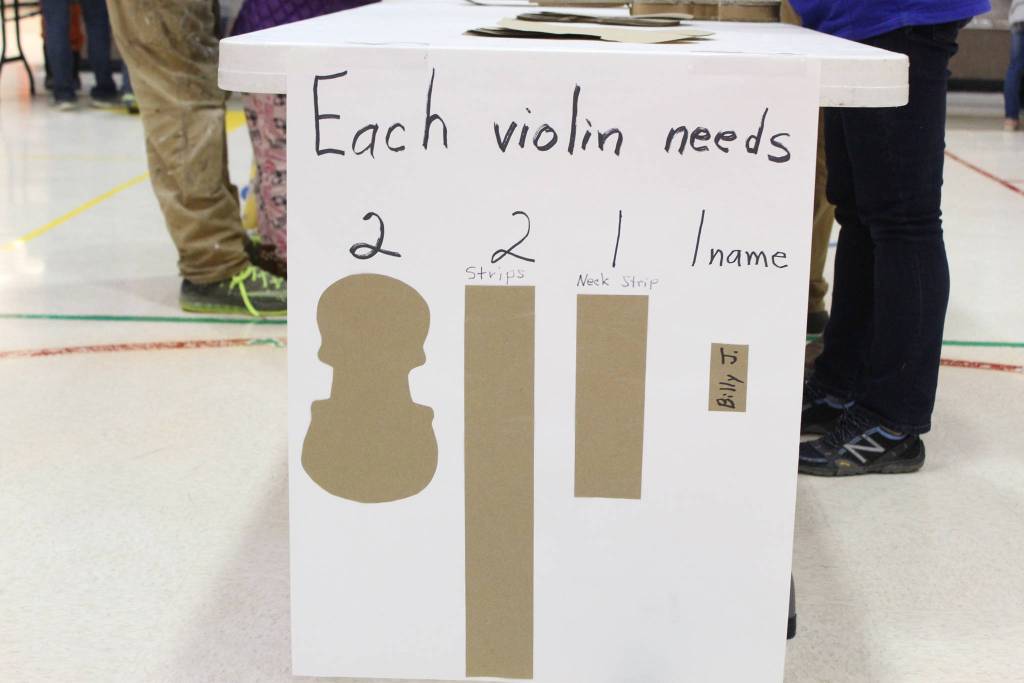 A sign advises students and parents how to make cardboard violins during a craft night at Paul Bank Elementary School on Thursday, Sept. 6, 2018 at the school in Homer, Alaska. The project is part of the schools Preludes Violin Program, which teaches first and second grade students musicianship and the host of skills that come with it. Students start out with the cardboard violins before graduating to the real instruments later in the year. (Photo by Megan Pacer/Homer News)
