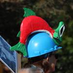 A rally participants listens to a speaker while wearing a salmon hat Saturday, Sept. 8, 2018 during a local version of the Rise for Climate, Jobs and Justice rally and march at WKFL Park in Homer, Alaska. Larger rallies were held all over the country that day. (Photo by Megan Pacer/Homer News)