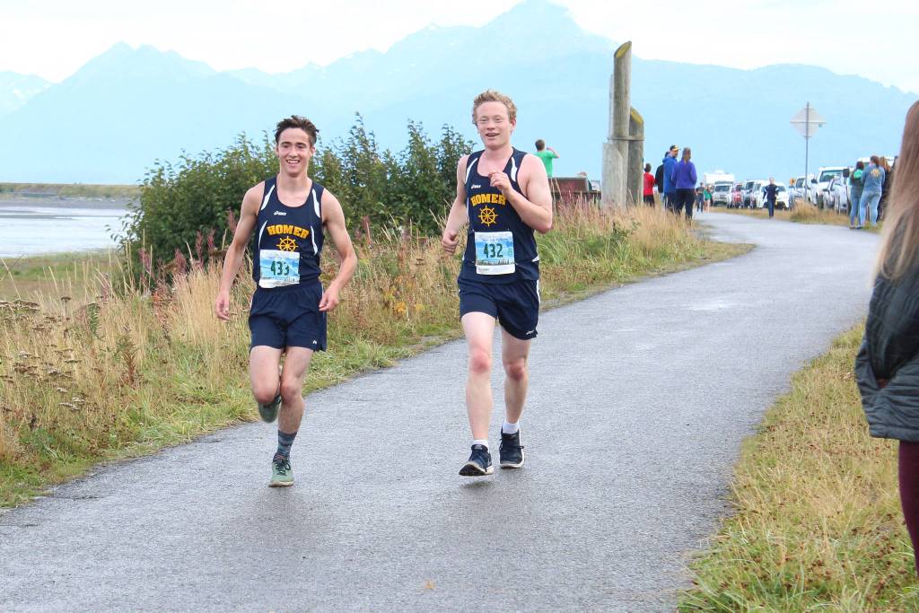 Homers Seth Inama (left) and Mose Hayes (right) approach the finish line of the boys 5K race together during the Homer Invitational for cross country Saturday, Sept. 7, 2018 on the Homer Spit in Homer, Alaska. (Photo by Megan Pacer/Homer News)
