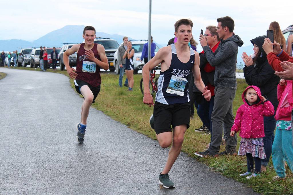 Soldotnas Nathanael Johnson approaches the finish line of the boys 5K Spit Run with Nikolaevsk Schools Justin Trail on his heels Saturday, Sept. 7, 2018 during the Homer Invitational held on the Homer Spit in Homer, Alaska. (Photo by Megan Pacer/Homer News)