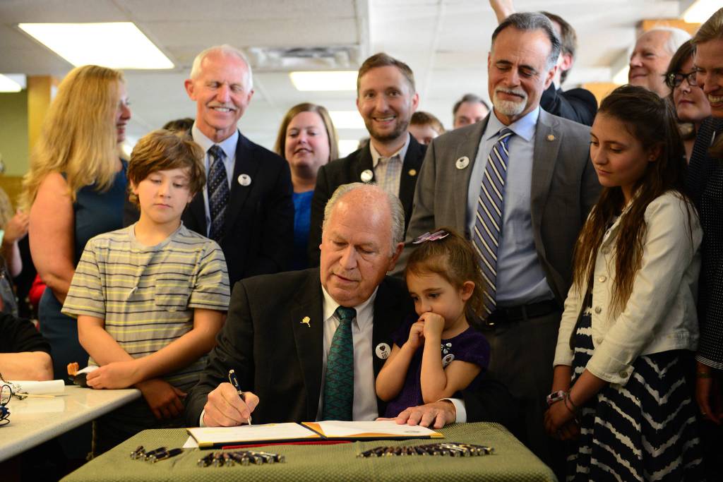 In a photo provided by the office of the governor, Gov. Bill Walker signs Senate Bill 63, a statewide public smoking ban, on Tuesday, July 17, 2018, at the Lucky Wishbone restaurant in Anchorage. The law goes into effect on Oct. 1. Standing at right is Sen. Peter Micciche, R-Soldotna, the legislative sponsor of the bill. On Walkers lap is Stella Micciche, one of Micciches daughters. Also visible, from right to left behind Walker are Dr. Jay Butler, Alaskas chief medical officer; Rep. Geran Tarr, D-Anchorage; Rep. Jason Grenn, I-Anchorage; Micciche; Rep. Chris Birch, R-Anchorage; and the smile of Emily Nenon of the American Cancer Society. (Courtesy photo)