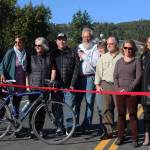 From left to right: Homer City Council member Donna Aderhold, council member Shelly Erickson, Save-U-More Assistant Manager Brian Namis, Public Works Director Carey Meyer, Council member Caroline Venuti, council member Heath Smith, council member Rachel Lord and City Manager Katie Koester celebrate the grand opening of the expanded Greatland Street with a ribbon cutting Tuesday, Sept. 25, 2018 in Homer, Alaska. (Photo by Megan Pacer/Homer News)