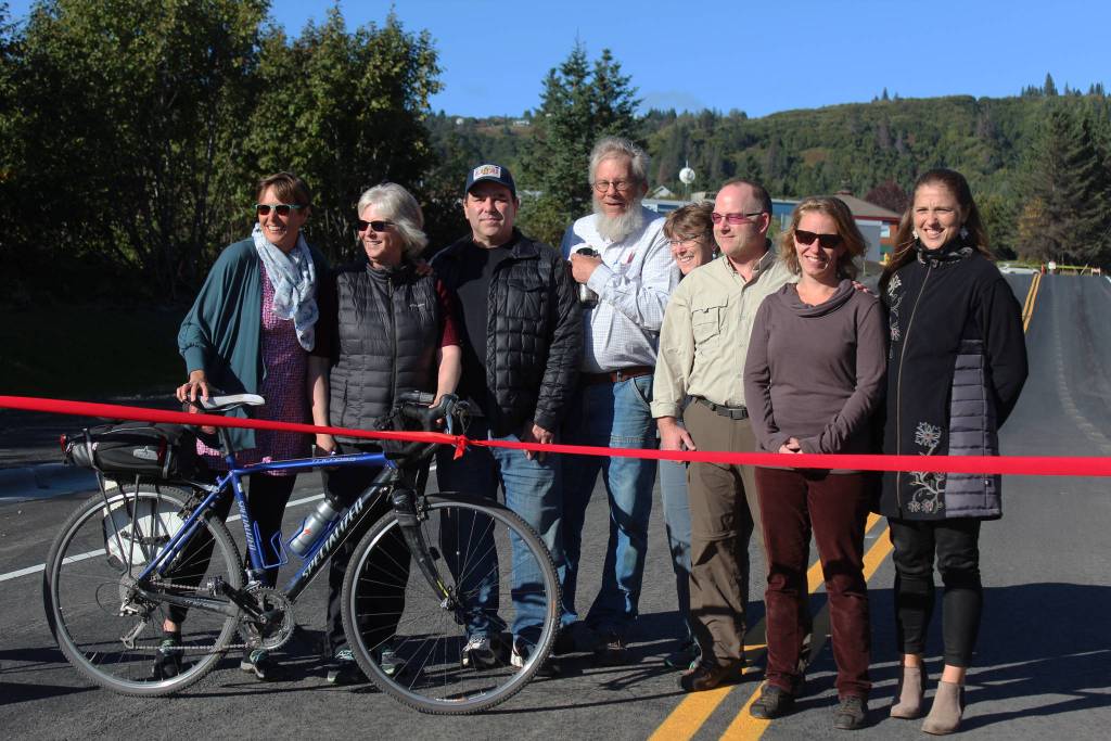 From left to right: Homer City Council member Donna Aderhold, council member Shelly Erickson, Save-U-More Assistant Manager Brian Namis, Public Works Director Carey Meyer, Council member Caroline Venuti, council member Heath Smith, council member Rachel Lord and City Manager Katie Koester celebrate the grand opening of the expanded Greatland Street with a ribbon cutting Tuesday, Sept. 25, 2018 in Homer, Alaska. (Photo by Megan Pacer/Homer News)