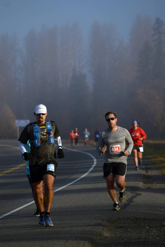 Michael Eriks of Carterville, Illinois, leads a pack of Kenai River Marathon racers through the early morning fog on Sunday, Sept. 30, 2018, on Bridge Access Road. (Photo by Jeff Helminiak/Peninsula Clarion)