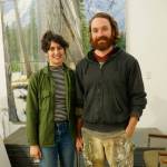 Elissa and David Pettibone pose on Tuesday, Oct. 16, 2018, by one of David Pettibones paintings at The Shop, an art space the Pettibones started in August 2018 in Kachemak City, Alaska. (Photo by Michael Armstrong/Homer News)