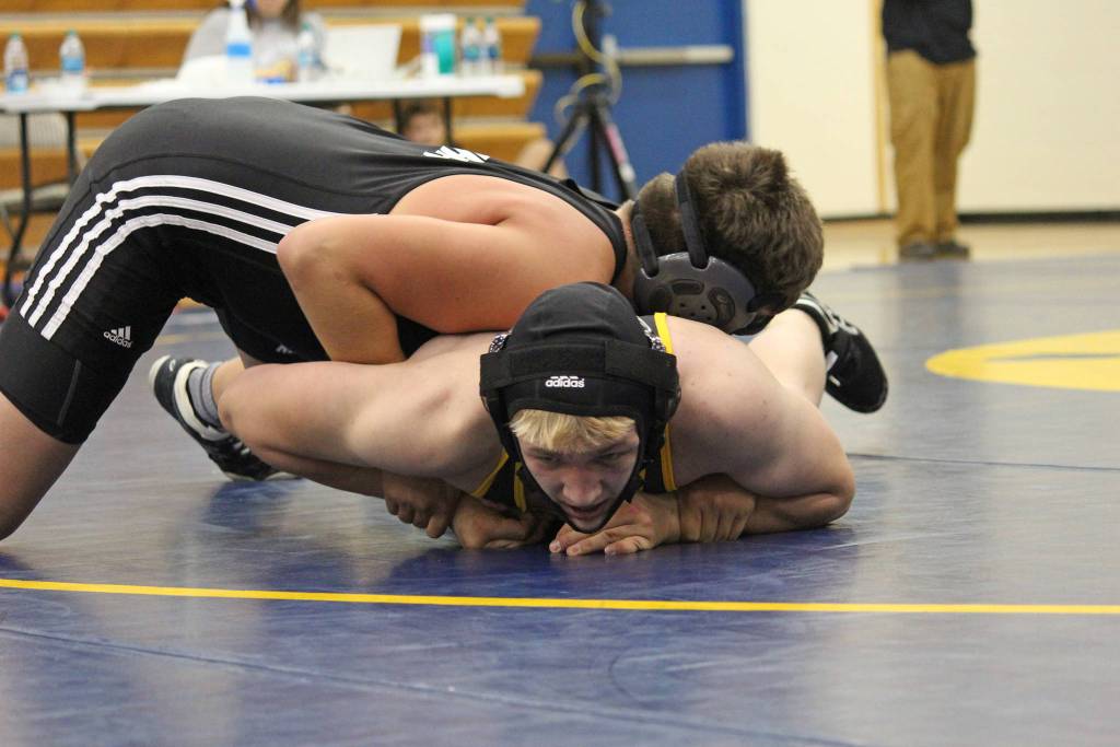 Antonin Murachev struggles to get out from under Nikiskis Simon Grenier during a dual meet Friday, Oct. 19, 2018 at Homer High School in Homer, Alaska. Grenier would go on to win the 152-pound weight class match. (Photo by Megan Pacer/Homer News)
