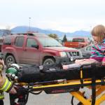Three-year-old Lenore Jones experiences what a ride on a stretcher is like, courtesy of Jason Miller of Kachemak Emergency Services, during the annual Rotary Health Fair on Saturday, Nov. 3, 2018 held at Homer High School in Homer, Alaska. (Photo by Megan Pacer/Homer News)