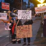 Democrats and Republicans share the sidewalk in front of WKFL Park on election day, Nov. 6, 2018, in Homer, Alaska. (Photo by Michael Armstrong/Homer News)