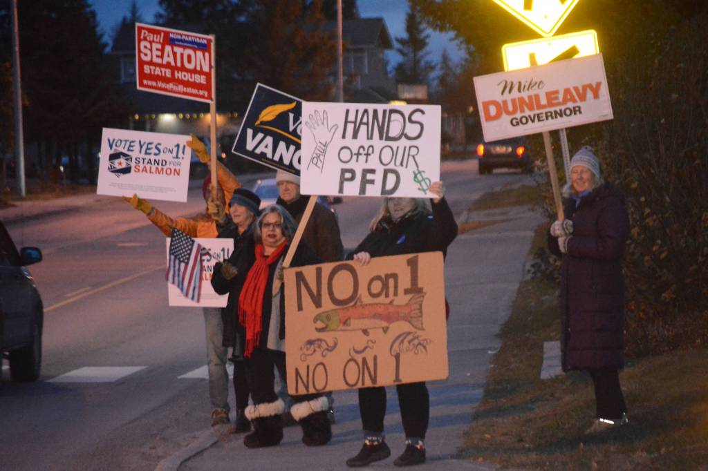 Democrats and Republicans share the sidewalk in front of WKFL Park on election day, Nov. 6, 2018, in Homer, Alaska. (Photo by Michael Armstrong/Homer News)
