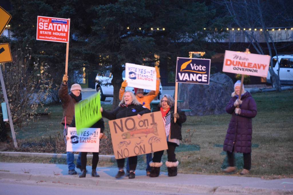 Democrats and Republicans share the sidewalk in front of WKFL Park on election day, Nov. 6, 2018, in Homer, Alaska. (Photo by Michael Armstrong/Homer News)
