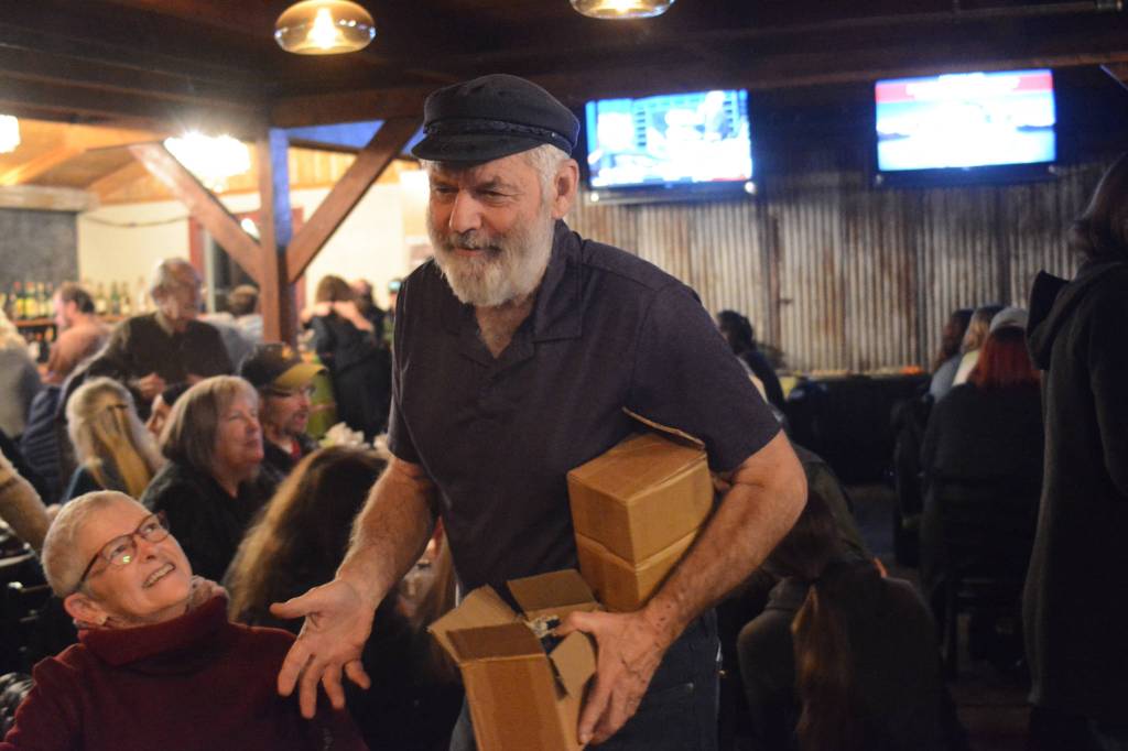 Rep. Paul Seaton hands out flashlights at an election night party at Alices Champagne Palace on Nov. 6, 2018, in Homer, Alaska. (Photo by Michael Armstrong/Homer News)
