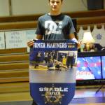 Homer High School senior Skyler Shadle, son of Jackie Eisenberg, holds a banner recognizing him at Senior Night, the Homer-Kenai dual wrestling meet held Nov. 21, 2018, in the Homer High School Alice Witte Gym, Homer, Alaska. (Photo by Michael Armstrong/Homer News)