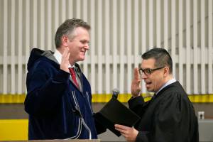 Mike Dunleavy, left, is sworn into office as Alaskas governor by Superior Court Judge Paul Roetman in Kotzebue, Alaska, on Monday, Dec. 3, 2018. Poor visibility forced Dunleaveys swearing-in ceremony to be held in Kotzebue instead of Noorvik, Alaska, his wifes hometown. (Stanley Wright/Alaska Governors Office via AP)