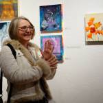 Sharlene Cline talks about her painting, Poppies, at the First Friday, Dec 7, 2018, opening of Bunnell Street Arts Centers 10x10 show in Homer, Alaska. (Photo by Michael Armstrong/Homer News)