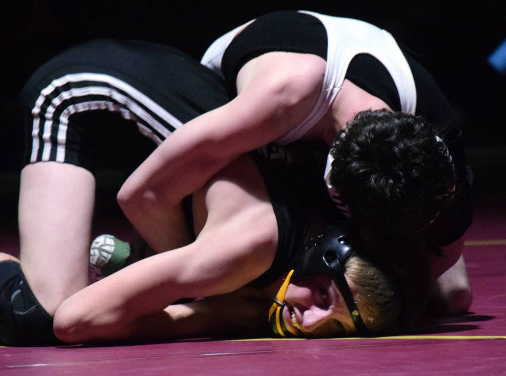 Nikiskis Jaryn Zoda battles against Caleb OHara of ACS on Saturday, Dec. 8, 2018 in the 112-pound championship at the Kachemak Conference wrestling tournament at Grace Christian High School in Anchorage, Alaska. (Photo by Joey Klecka/Peninsula Clarion)