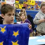Chapman 4th-grade student Miles Tressler displays a Flag of Peace he painted on Dec. 6, 2018 at Chapman School in Anchor Point, Alaska. (Photo provided)