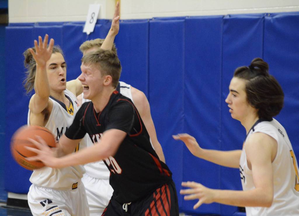 Kenai Centrals Andrew Bezdecny tries to break away from the Homer defense Friday, Dec. 21, 2018, at the Homer High School Alice Witte Gym in Homer, Alaska. (Photo by Michael Armstrong/Homer News)