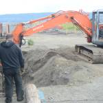 John Wise, left, and Nathan Wise, right, in backhoe, make repairs of the Glacier Drive-In on the Homer Spit, on Aug. 16, 2018, after a series of storms that eroded the beach last week during high tides in Homer, Alaska. (Homer News file photo)