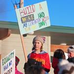 A girl holds up a sign reading, Build a wall and my generation will tear it down, at WKFL Park following the 2019 Womens March on Homer on Saturday, Jan. 19, 2019 in Homer, Alaska. (Photo by Megan Pacer/Homer News)
