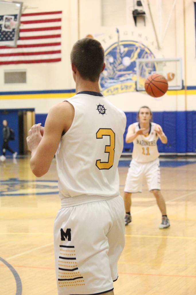 Homers Clayton Beachy (foreground) launches a pass to teammate Daniel Reutov during a Friday, Jan. 25, 2019 game against Nikiski at Homer High School in Homer, Alaska. (Photo by Megan Pacer/Homer News)