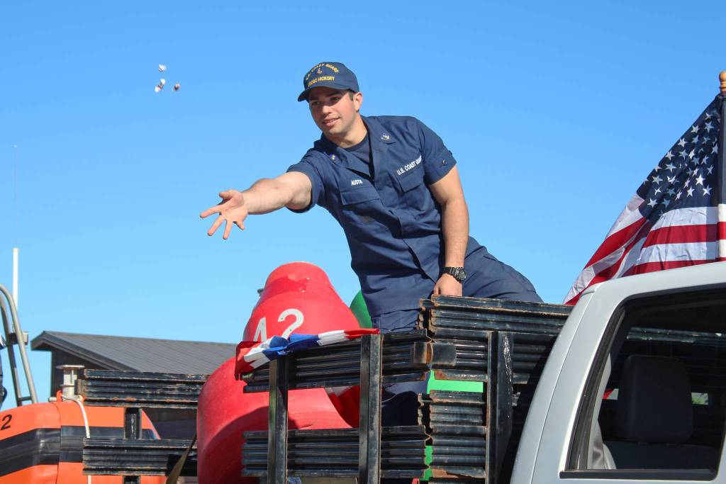 A member of the U.S. Coast Guard tosses candy to children and families lining Pioneer Avenue during the annual Independence Day parade Wednesday, July 4, 2018 in Homer, Alaska. Coast Guard participants were representing the U.S. Coast Guard Cutter Hickory, also called the Bull of the North. (Photo by Megan Pacer/Homer News)                                A member of the U.S. Coast Guard tosses candy to children and families lining Pioneer Avenue during the annual Independence Day parade Wednesday, July 4, 2018 in Homer, Alaska. Coast Guard participants were representing the U.S. Coast Guard Cutter Hickory, also called the Bull of the North. (Photo by Megan Pacer/Homer News)