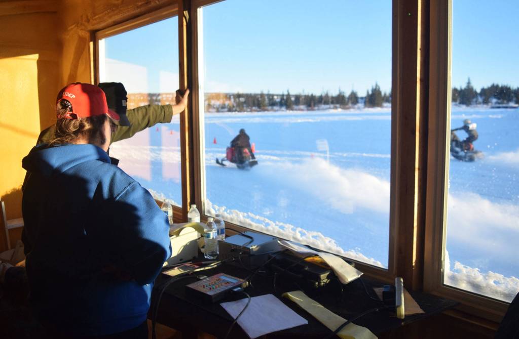 Emily Pollard keeps track of scoring and timing Saturday afternoon at the snowmachine drag races at Freddies Roadhouse near Ninilchik. (Photo by Joey Klecka/Peninsula Clarion)