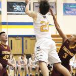 Homers Ethan Anderson jumps between Mt. Edgecumbes Jeff Adams (left) and Leon Toomer (right) for a shot during a Thursday, Jan. 10, 2019 game in Homer, Alaska. (Photo by Megan Pacer/Homer News)