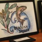 One of several beer label submissions sits on display Friday, Feb. 1, 2019 at a First Friday event at Grace Ridge Brewery in Homer, Alaska. The Brackish Brown ale, bottled with the winning label, was available at the event. (Photo by Megan Pacer/Homer News)