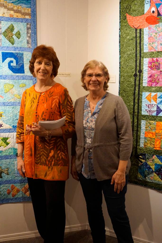 Patrice Krant, left, and Janet Bacher, right, stand by their quilts in the 9 Women / 9 Quilts show that opened last Friday, Feb. 1, 2019, at the Homer Council on the Arts, in Homer, Alaska. (Photo by Michael Armstrong/Homer News)