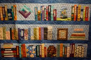A close-up of Ruby Nofzigers On a Bookshelf quilt, one of the works in the 9 Women / 9 Quilts show that opened last Friday, Feb. 1, 2019, at the Homer Council on the Arts, in Homer, Alaska. Each panel or row of books was done by a different quilter. (Photo by Michael Armstrong/Homer News)