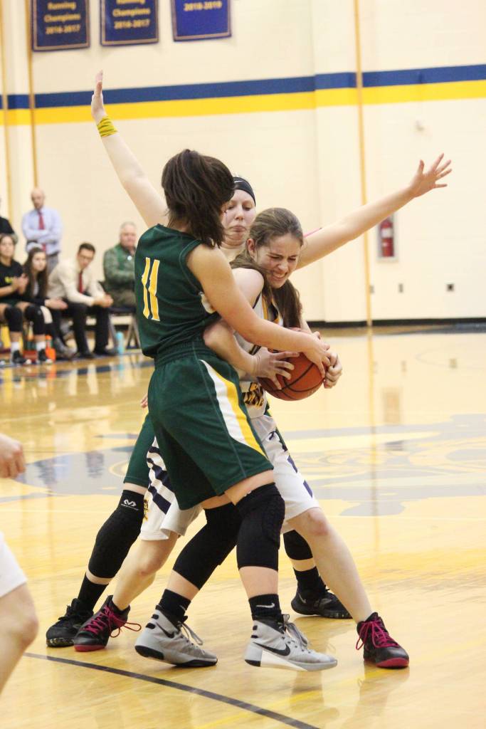 Homers Laura Inama tries to keep the ball away from Sewards Anevay Ammbrosiani (No. 11) and Katelyn Lemme (background) Friday, Feb. 8, 2019 during the Winter Carnival Basketball Tournament in Homer, Alaska. (Photo by Megan Pacer/Homer News)