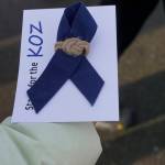 Nona Safra holds a ribbon handed out for Chief Warrant Officer Michael Kozloski on Friday morning, Feb. 8, 2019, at the Seafarers Memorial on the Homer Spit, Homer, Alaska. The blue fabric is from Coast Guard utility uniforms. (Photo by Michael Armstrong/Homer News)